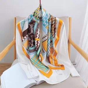 Detailed view of the luxury 90cm geometric printed silk scarf draped over a white blouse.