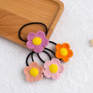 Closeup of handmade crochet flower hair ties with colorful yarn and elastic bands in detail.