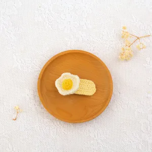 Handmade crochet hair clip detail shot, cute fried egg flower design, neat yarn accessory.