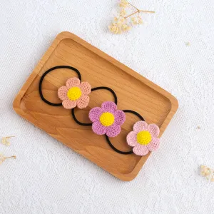 Handmade crochet flower hair tie set features colorful yarn floral designs on black elastic bands.