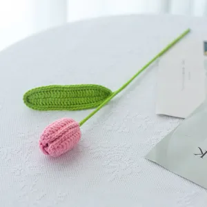 Primo piano di un fiore di tulipano rosa lavorato all'uncinetto con dettagli precisi.