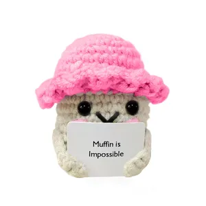 Peluche muffin all'uncinetto artigianale con cappello rosa e cartello di citazione vista dettaglio.