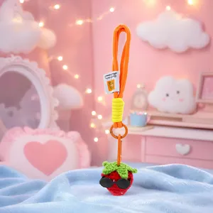 Détail de porte-clés fraise au crochet fait main, pendentif en peluche laine avec lunettes.