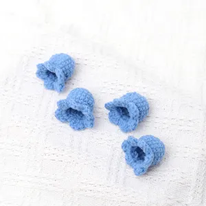 Handmade crochet blue lily of the valley flower head detail shot, soft wool knit craft decor.