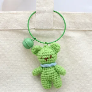 Handmade crochet green bear keychain detail, cute plush bag charm with bell pendant.