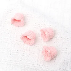 Handmade crochet lily-of-the-valley flower heads, pink knit floral DIY craft accessory.