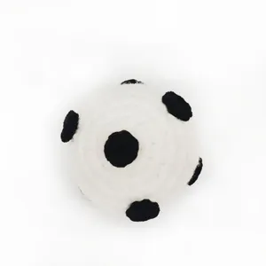 Handmade crochet soccer ball detail shot, mini white and black yarn ball ornament pendant.
