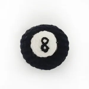 Close-up product detail showing the texture of the handmade crochet billiard 8-ball pendant.