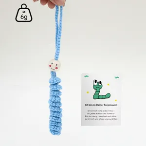 Handmade crochet worry worm detail view, cute blue hanging ornament with wooden bead face.