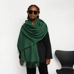 Detail view of a solid green tassel cashmere-feel scarf, cozy winter warm long shawl wrap for women.