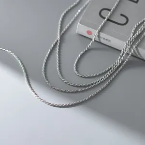 Silver rope chain necklace detail shot, delicate twisted design, elegant sterling silver jewelry style.