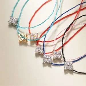 Detailansicht minimalistischer Kleeblatt Anhänger Armbänder mit bunten Kordeln.