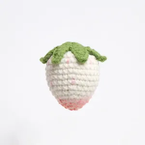 Handmade crochet strawberry detail close-up, cute knitted bag charm pendant accessory.
