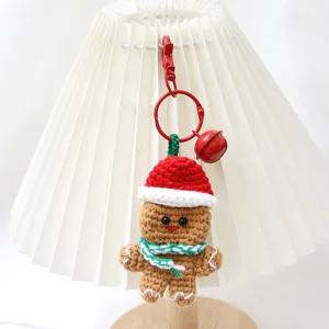 Handgefertigte Häkel-Lebkuchenmann-Schlüsselanhänger Details mit roter Mütze und Glocke.