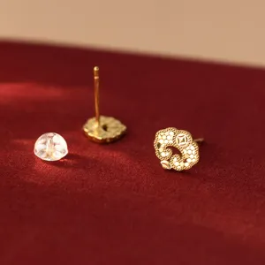 Gros plan détail boucles d'oreilles clou dorée motif nuage Ruyi, texture métallique fine et élégante.