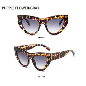 Modische Cat-Eye-Sonnenbrille mit lila Blumenmuster und grauen Verlaufsgläsern im Freien.