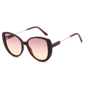 Modische Katzenauge Sonnenbrille mit Farbverlauf, rotem Gestell und goldenen Metallbügeln.