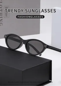 Modische schwarze ovale Katzenaugen Sonnenbrille mit eleganten Metalldetails für Damen.