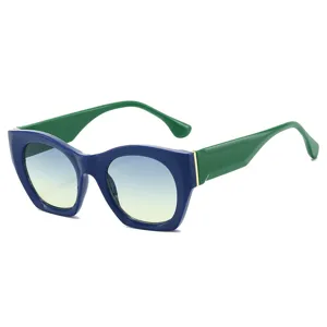 Modische Retro-Katzenauge-Sonnenbrille mit klobigem blauen Gestell und Verlaufsgläsern.