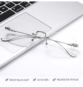 Nahaufnahme einer rahmenlosen Blaulichtfilterbrille mit filigranen Silberbügeln auf Laptop.