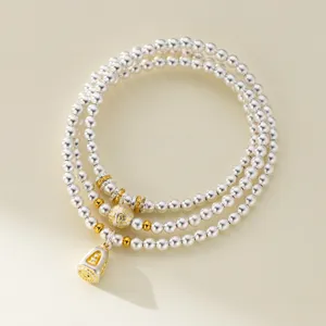 Detail view of a 999 fine silver three-layer beaded bracelet with gold-painted charm.
