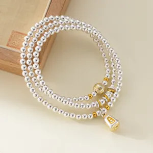 Sterling silver multi-layer beaded bracelet with intricate golden details and amulet pendant.