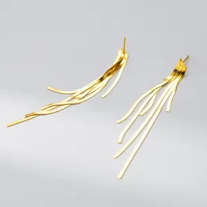 Close-up detail of the elegant gold tassel snake bone earrings, showcasing fine metal links.