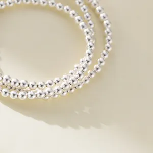 Detailed close-up shot of the three-layer silver bead bracelet showcasing fine texture.