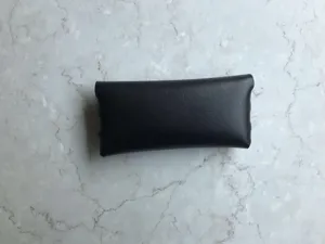 Detailansicht des tragbaren schwarzen Leder Brillenetuis im kompakten Brieftaschen Design.