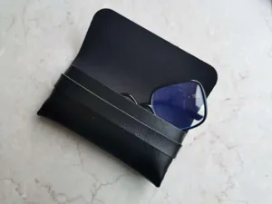 Tragbares kompaktes schwarzes Leder-Brillenetui Detailaufnahme mit weichem Innenfutter.