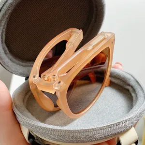 Detailansicht einer trendigen Klappsonnenbrille im runden Etui, ideal für Reisen unterwegs.