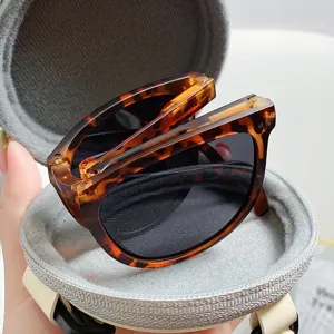Faltbare Schildpatt-Sonnenbrille in rundem grauen Reißverschluss-Etui Detailansicht.