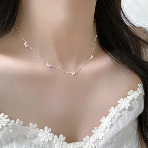 Detail shot of exquisite silver butterfly choker necklace with sparkling stones on model neck.