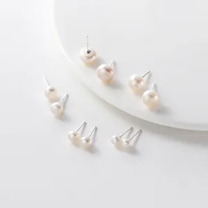 Detailed close-up view of elegant freshwater pearl stud earrings with sterling silver pins.