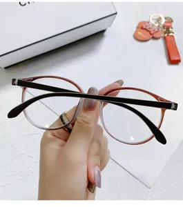 Primer plano de elegante montura de gafas óptica redonda marrón con patillas negras elegantes.