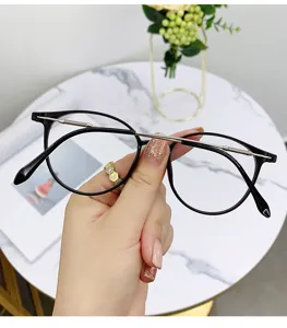 Elegante montatura per occhiali tonda ottica con dettaglio della barra superiore in metallo.