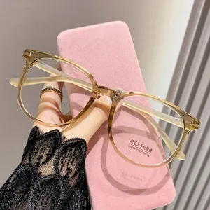 Primer plano de detalle de gafas bloqueadoras de luz azul estilo coreano con montura marrón.