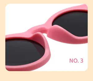 Detalle de gafas de sol infantiles de montura redonda rosa textura de plástico lisa lentes oscuras