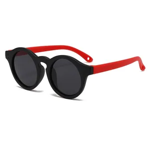 Gafas de sol polarizadas redondas retro para niños con montura negra y patillas rojas.