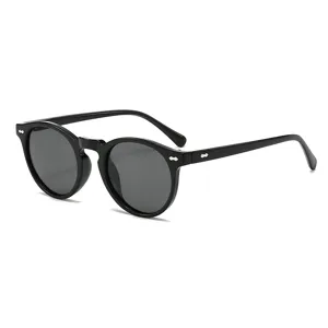 Lunettes de soleil rondes vintage pour hommes et femmes, monture noire avec rivets élégants.