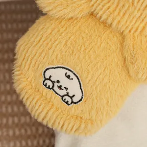 Vista detallada de chaleco de felpa amarillo para mascotas con bordado de perro tierno.