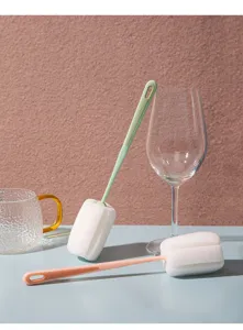 Close-up detail of long-handled sponge cup brush cleaning tool in a modern kitchen scene.