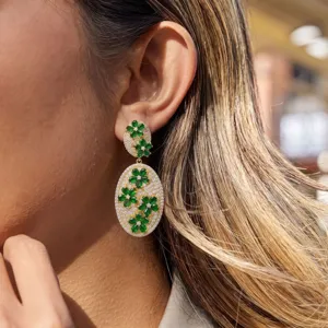 Detailansicht von exquisiten Diamant- und grünen Blumen-Ohrringen, elegantes Design am Ohr.
