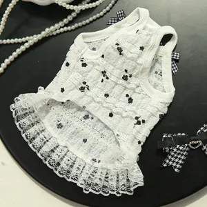 Vue détaillée de la jolie robe pour animal en dentelle blanche avec des motifs floraux noirs.