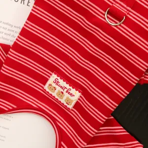 Close-up detail of red striped pet winter fleece clothes with metal D-ring and cute bear patch.