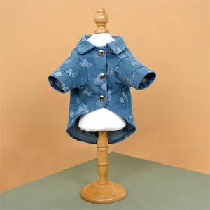 Dettaglio ravvicinato della camicia in denim per animali con stampa orsetto, bottoni e colletto.