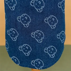 Dettaglio camicia di jeans cane stampa orso, tessuto morbido, abbigliamento animale.