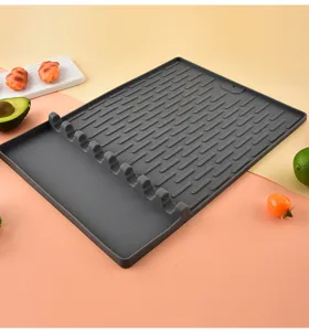 Dunkelgraue Silikon BBQ Grillmatte mit Ölablaufrillen und Werkzeughlitzen für Camping.
