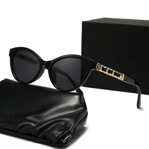 Donna moda occhiali da sole cat eye neri con eleganti stanghette catena oro e fiore.