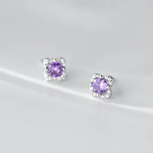Detailansicht von silbernen Ohrringen mit violettem Zirkonia, funkelndes Blumen-Design.